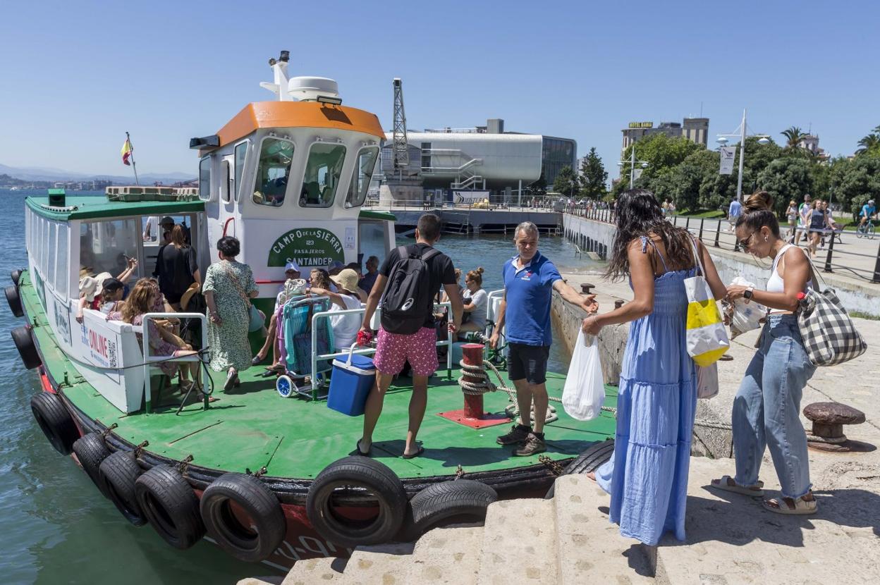 Un grupo de turistas sube a bordo de una pedreñera. 