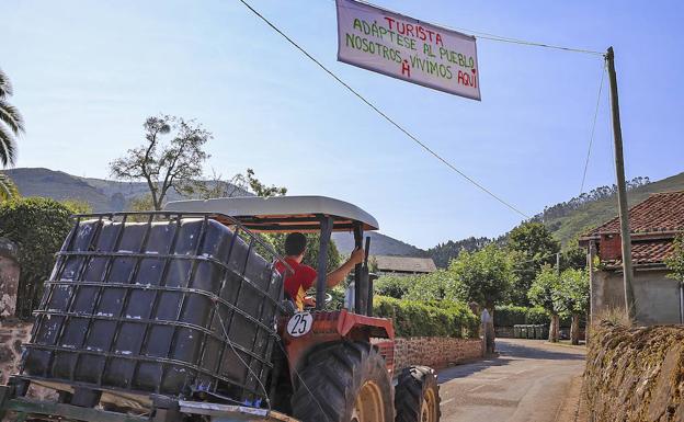 Un tractor circula bajo la advertencia colgada a la entrada del pueblo.