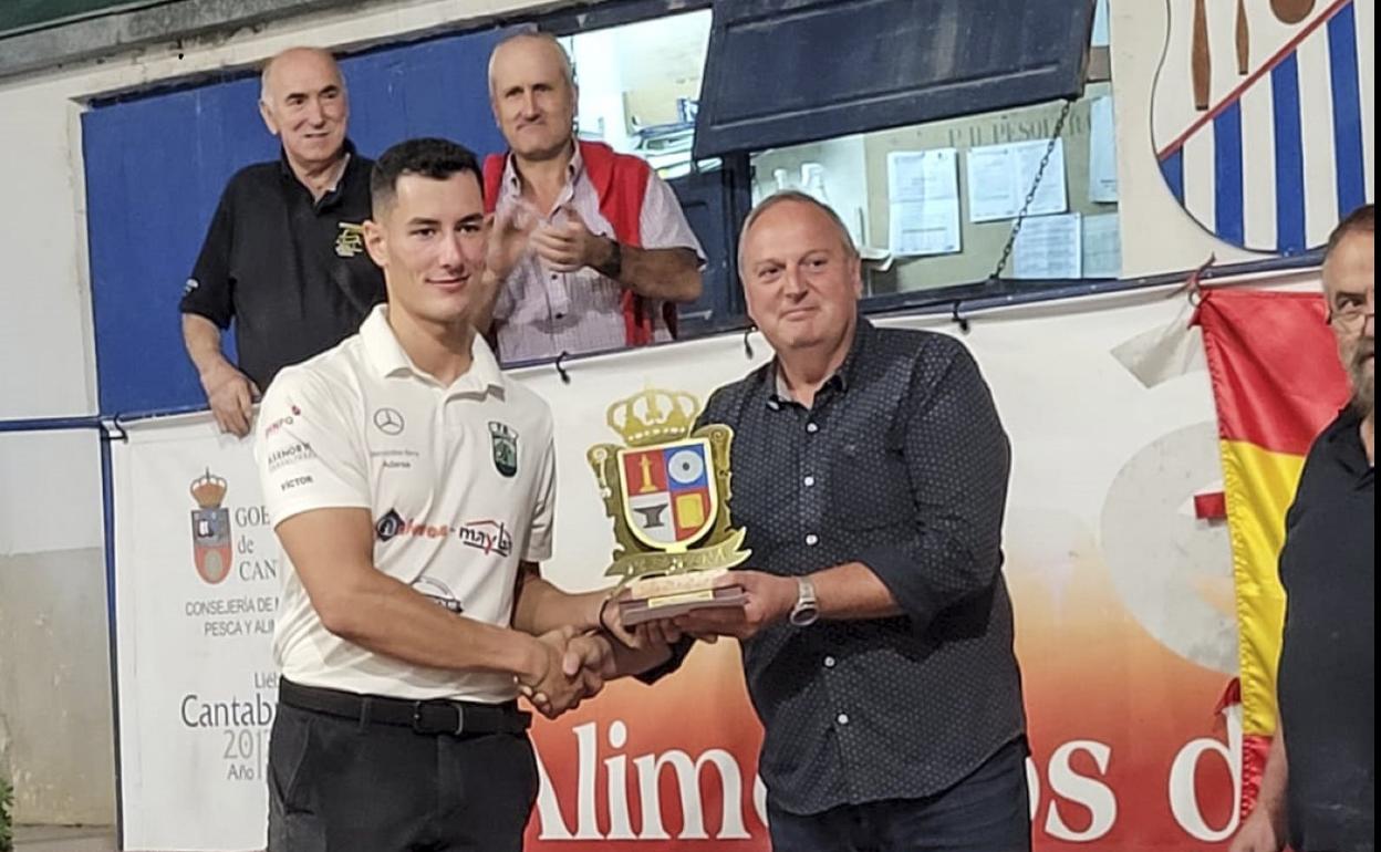 Víctor González recibe el trofeo de campeón de manos del alcalde de Pesquera, Rubén Ruiz