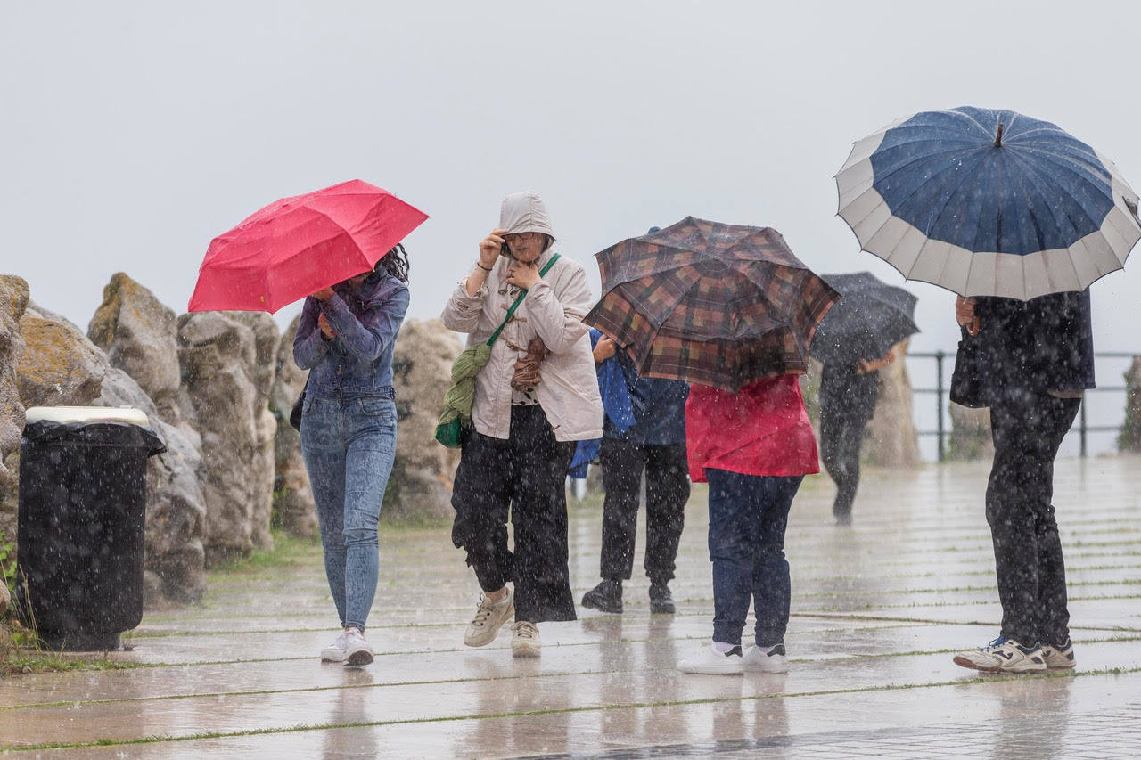 Fotos: Viandante bajo la lluvia en Santander, este miércoles