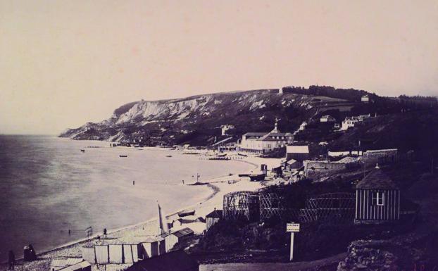 La vista de de los baños Dumont reproduce de nuevo el efecto de las mareas mostrando la playa muy recortada como consecuencia de la pleamar. Rescata la fisonomía decimonónica del paraje costero.