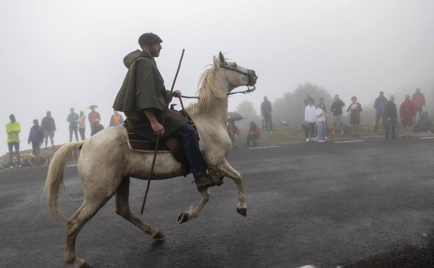 Imagen principal - Un jinete por la carretera de Pico Jano, la niebla que marcó la jornada y paso del pelotón por el arco de La Cavada.