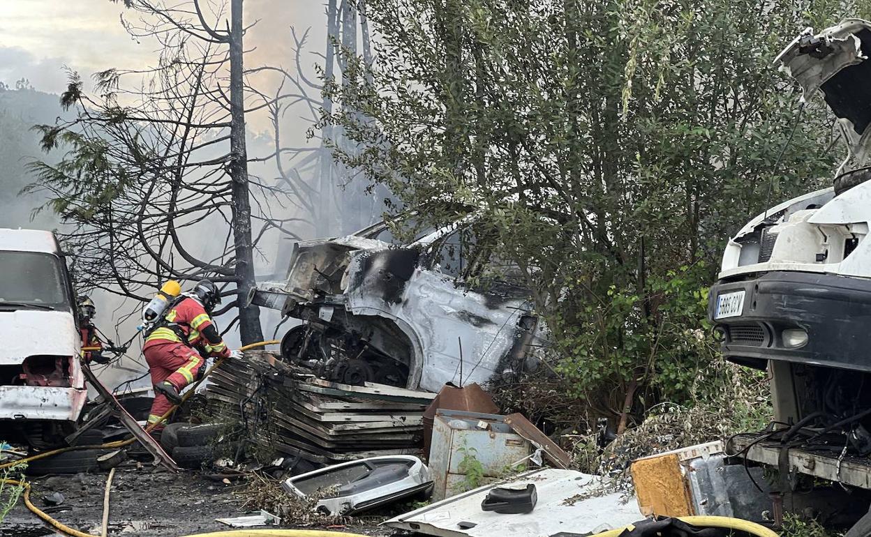 Un bombero sofoca las llamas en el desguace ilegal de Socobio, en Castañeda 