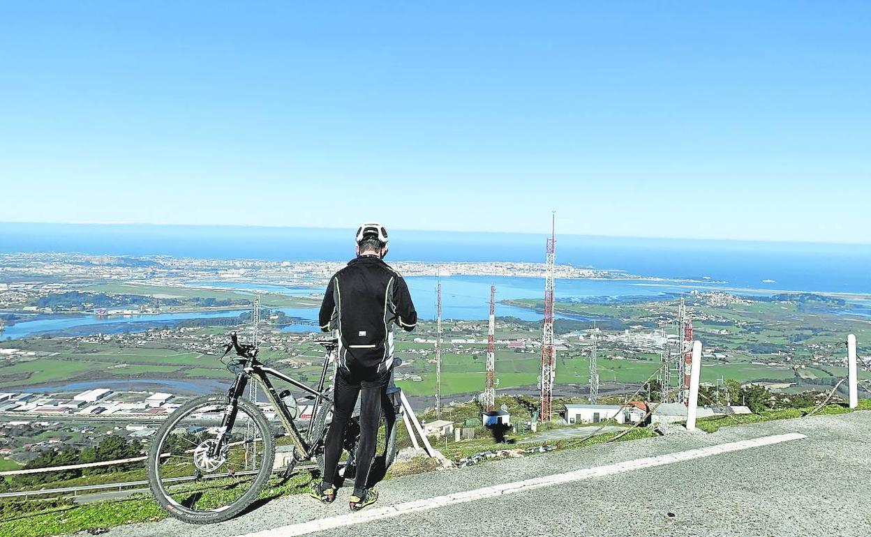 Un ciclista contempla las vistas desde el mirador del pico Llen con Santander y su bahía al fondo. 