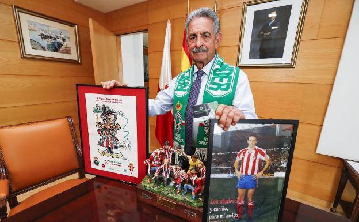 Miguel Ángel Revilla, en su despacho, con los premios del Gesto Sportinguista, una foto dedicada de Quini y su carné del Racing.