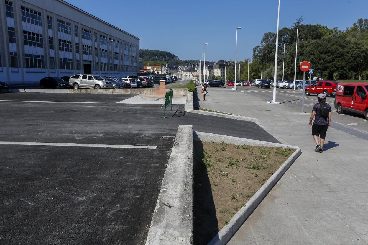 Un vecino camina junto a la zona de estacionamiento, aún vallada, ayer, en el exterior del ferial de Ganados de Torrelavega. 