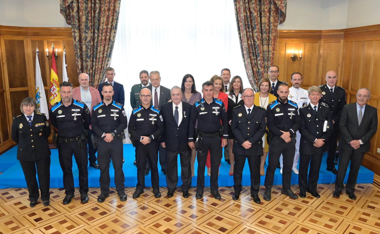 Los premiados con las Cruces al Mérito posan junto a las autoridades en el salón de actos del Palacio de La Magdalena.