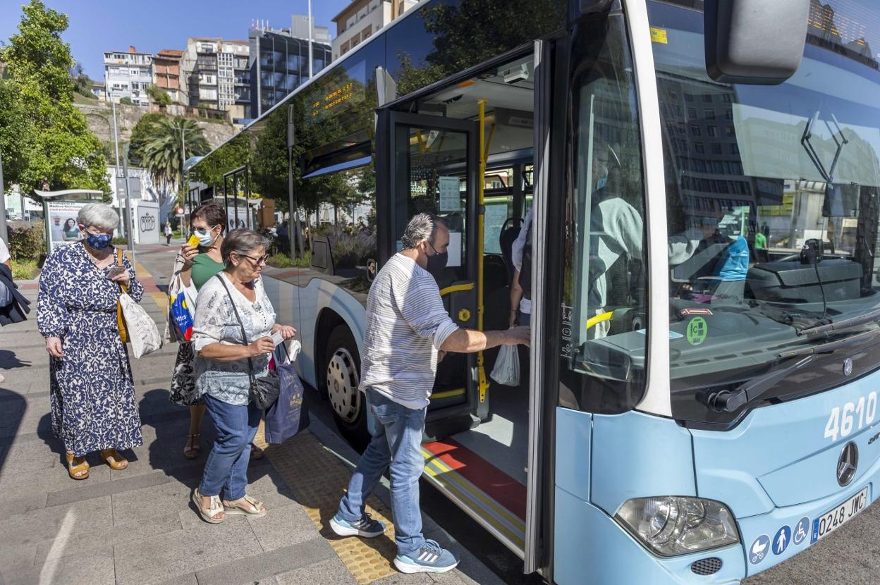 Usuarios del Transporte Urbano de Santander (TUS) hacen cola en una parada de la ciudad para subir a uno de los autobuses. 