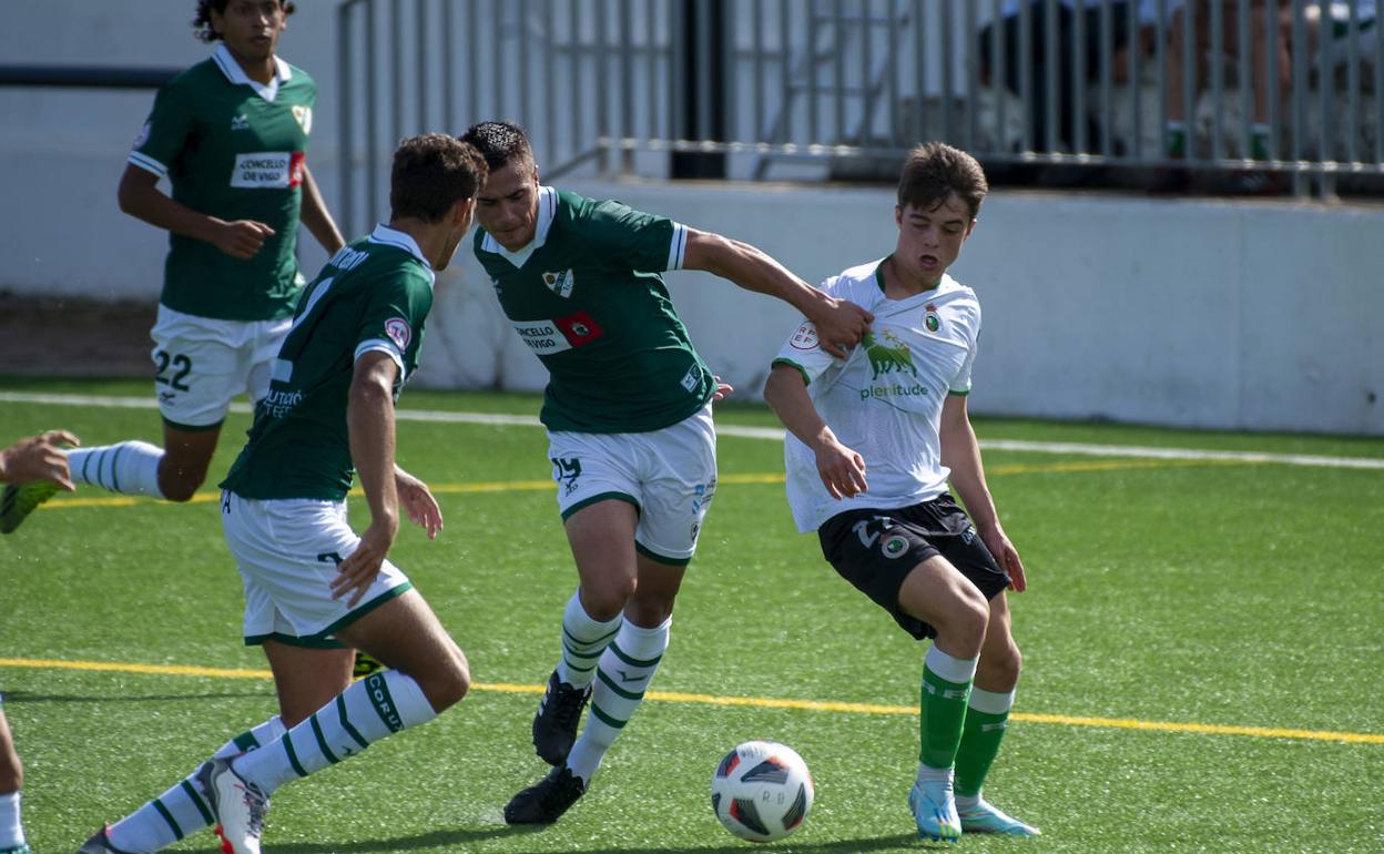 Neco Celorio, del Rayo Cantabria, lucha por el balón con un jugador del Coruxo