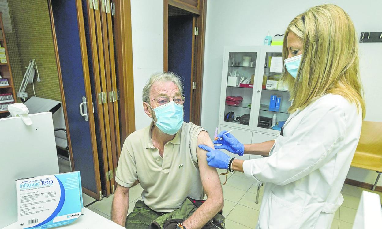 Una enfermera administra la vacuna contra la gripe a un hombre en el centro de salud de Puertochico. 