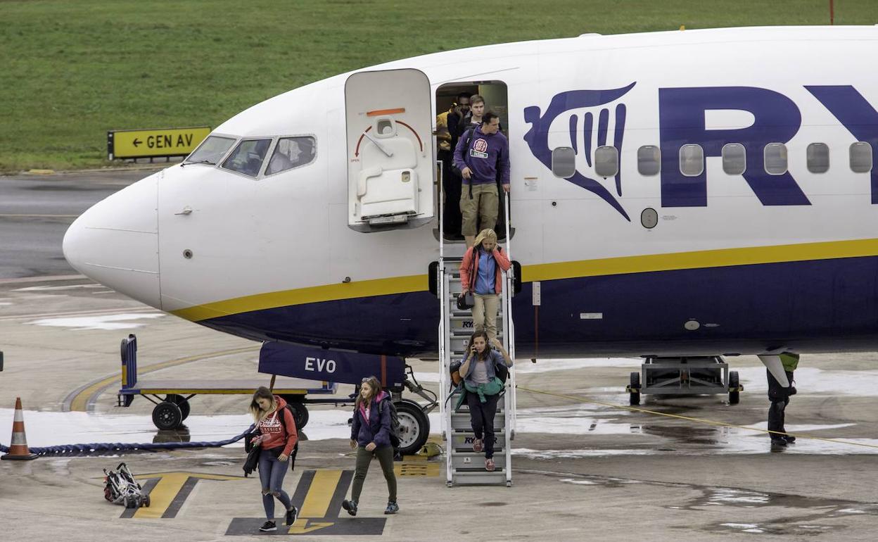 Pasajeros atraviesan la pista del Seve tras aterrizar de un vuelo procedente de Londres
