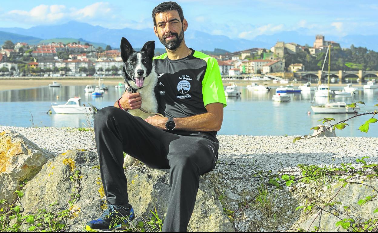 Fidel Fernández, con su inseparable perro Zar, con San Vicente de la Barquera y los Picos de Europa al fondo. 