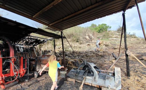 La familia de Iván Saiz entre la maquinaria calcinada por el fuego en su casa en el barrio El Burco, en Quijas.