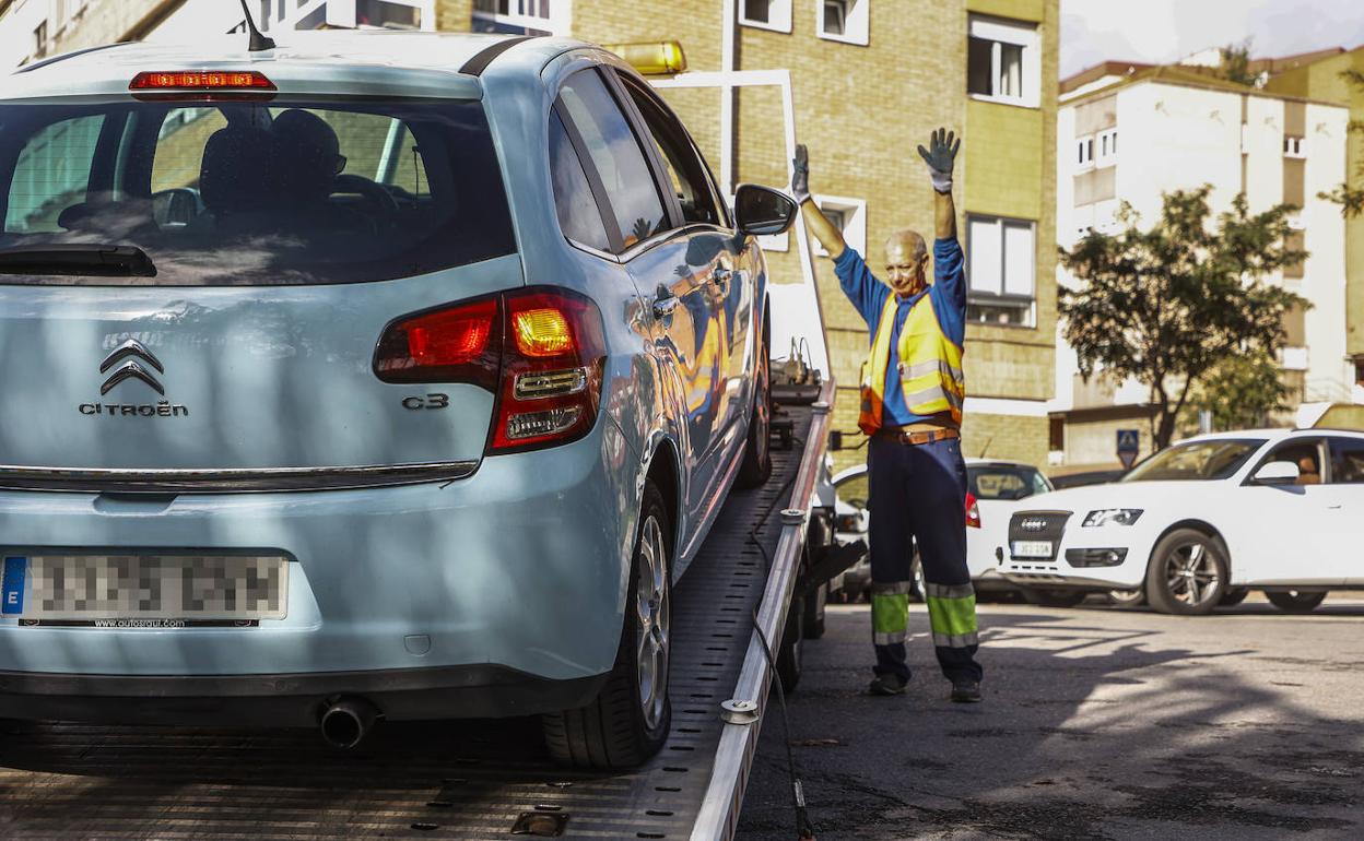 Uno de los vehículos afectados por el vandalismo subido a la grúa.