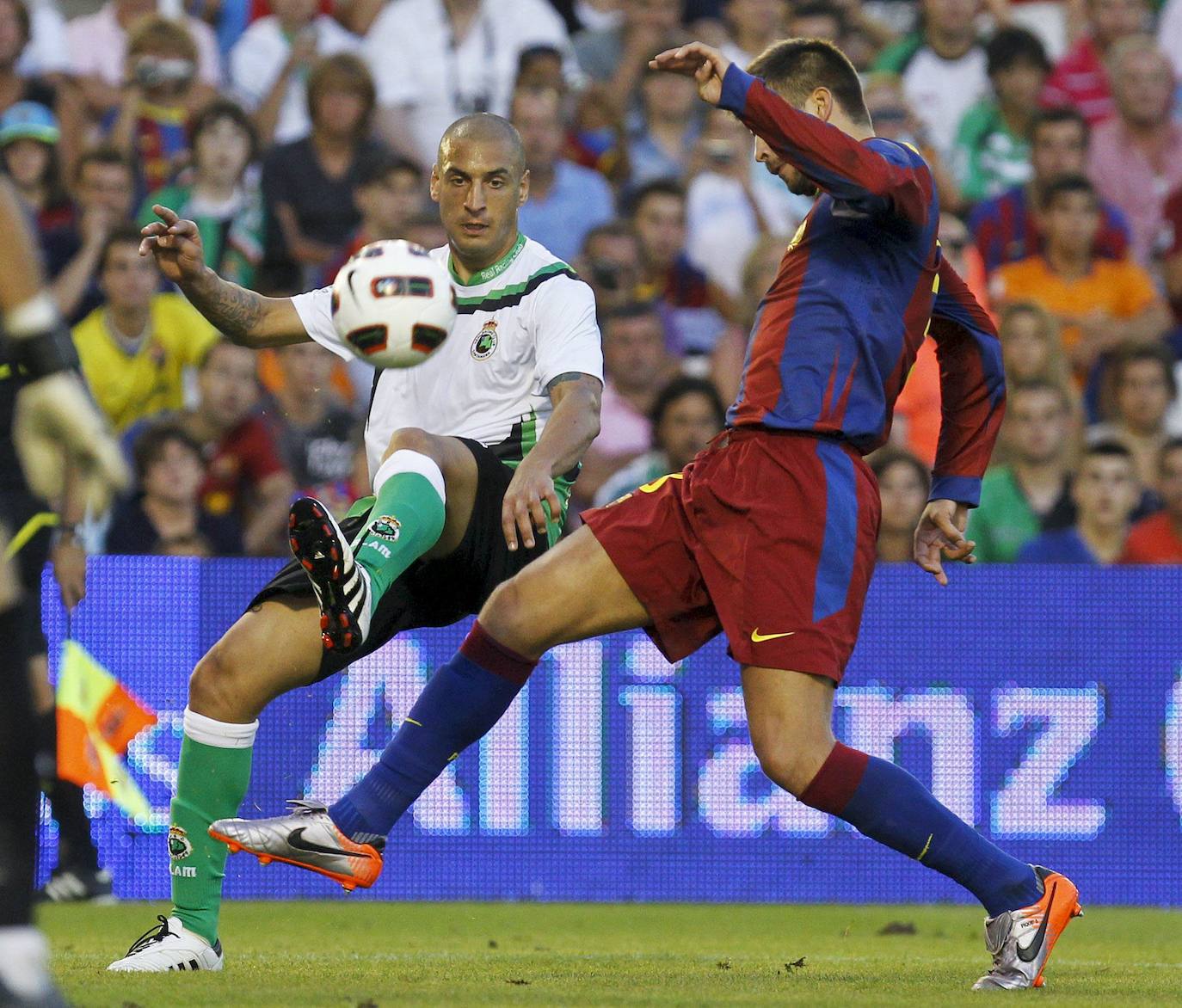 Foto de agosto de 2010 en la que el delantero argentino del Racing Ariel Nahuelpan trata de controlar el balón ante Gerard Piqué, durante el partido disputado en el estadio de El Sardinero. El encuentro terminó 0-3 