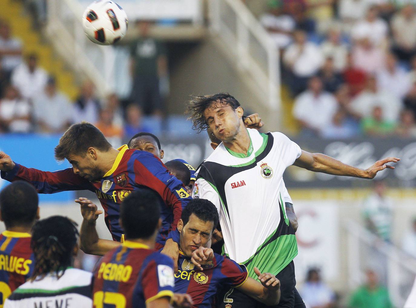 Foto de agosto de 2010 en la que el defensa brasileño del Racing, Henrique Adriano lucha la pelota con el defensa Gerard Piqué. El partido terminó 0-3.