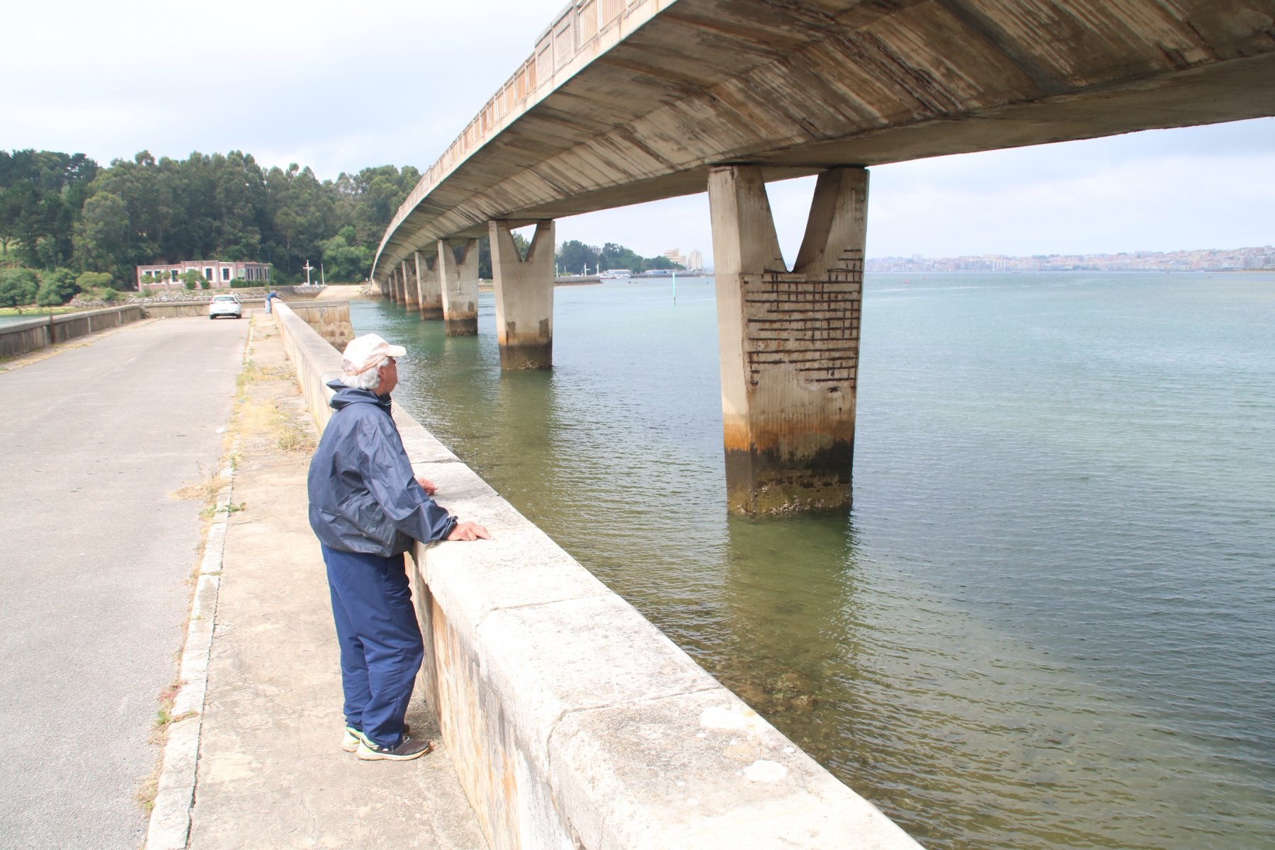 Un pescador contempla uno de los pilares del puente de Somo mas perjudicados por la corrosión. 