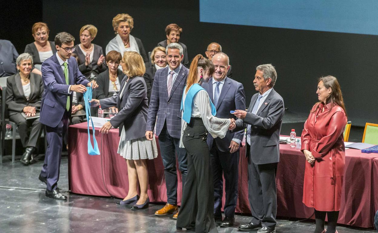 Autoridades académicas e institucionales, en la apertura del curso, imponiendo las bandas a los alumnos que han completado sus estudios.