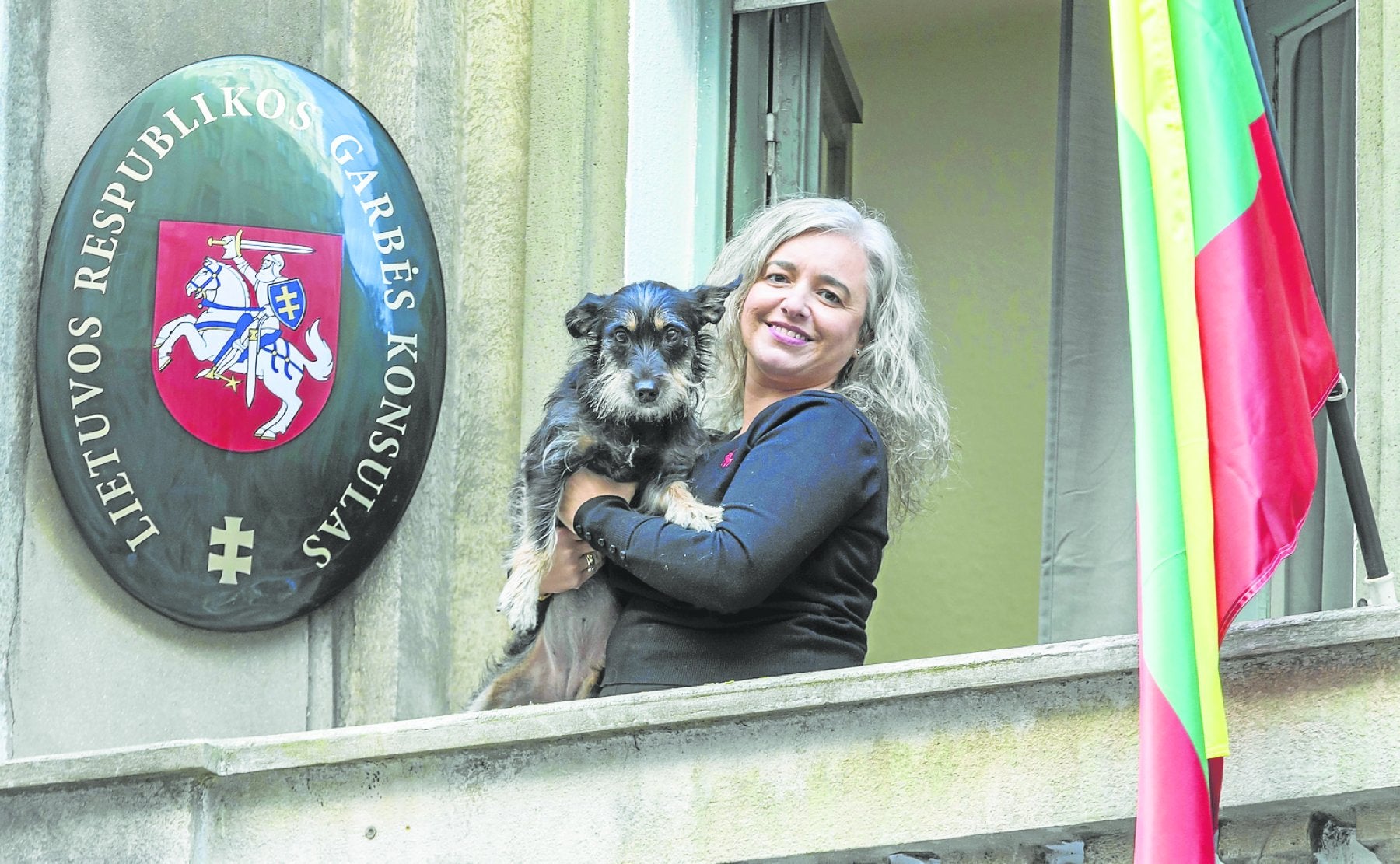 La consultora Ana Belén Gutiérrez, cónsul honoraria de Lituania en Cantabria, posa con Nuca en el balcón del consulado. 