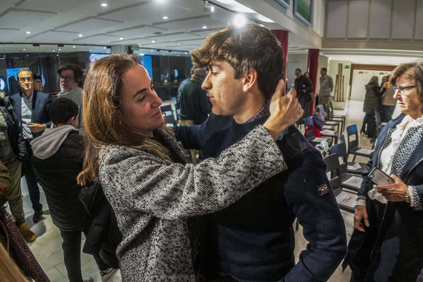 Un familiar saluda a Nicolás Fernández, el joven que ha recibido la Medalla de Oro. 