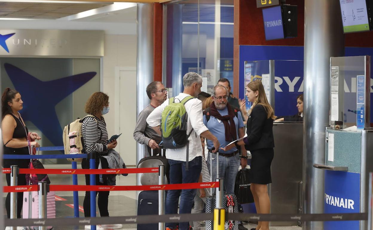 Un grupo de pasajeros, ante el mostrador de Ryanair en el aeropuerto.