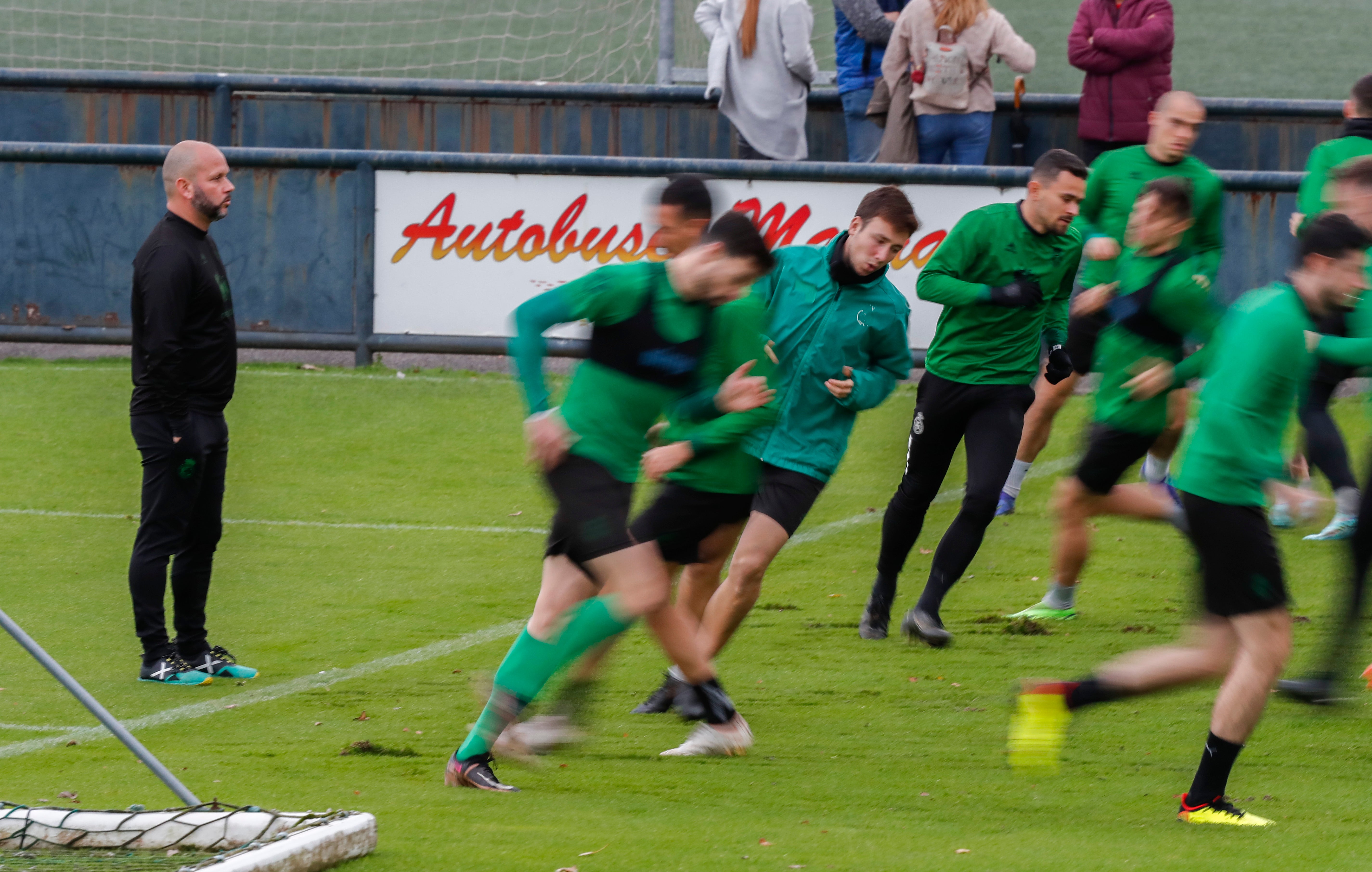 El entrenador observa al equipo mientras realiza ejercicios de entrenamiento. 