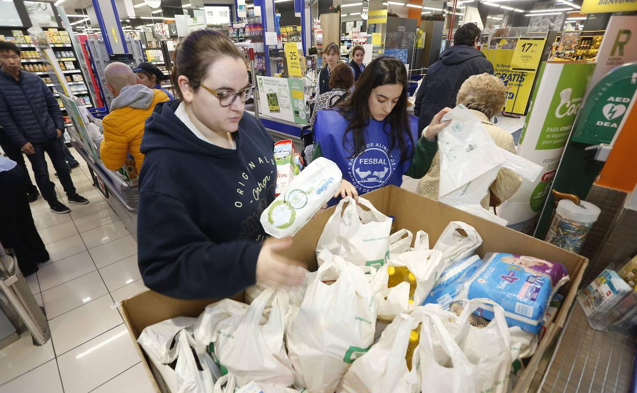 Una joven y una voluntaria, en un supermercado, durante la Gran Recogida de Alimentos de este año.