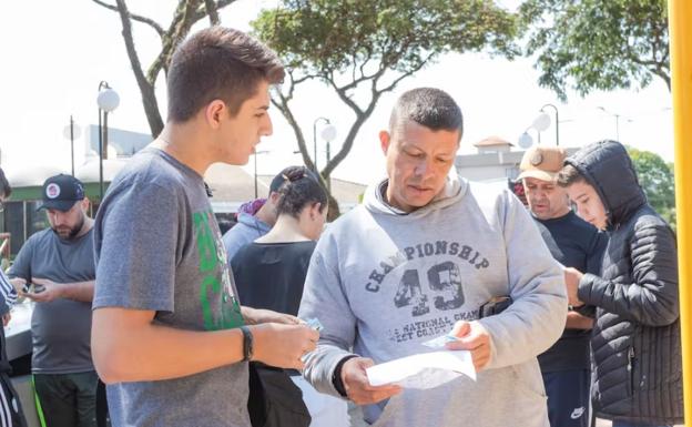 Coleccionistas brasileños intercambian sus cromos repetidos del Mundial de Fútbol de 2022 en una plaza de Apucarana, Brasil.