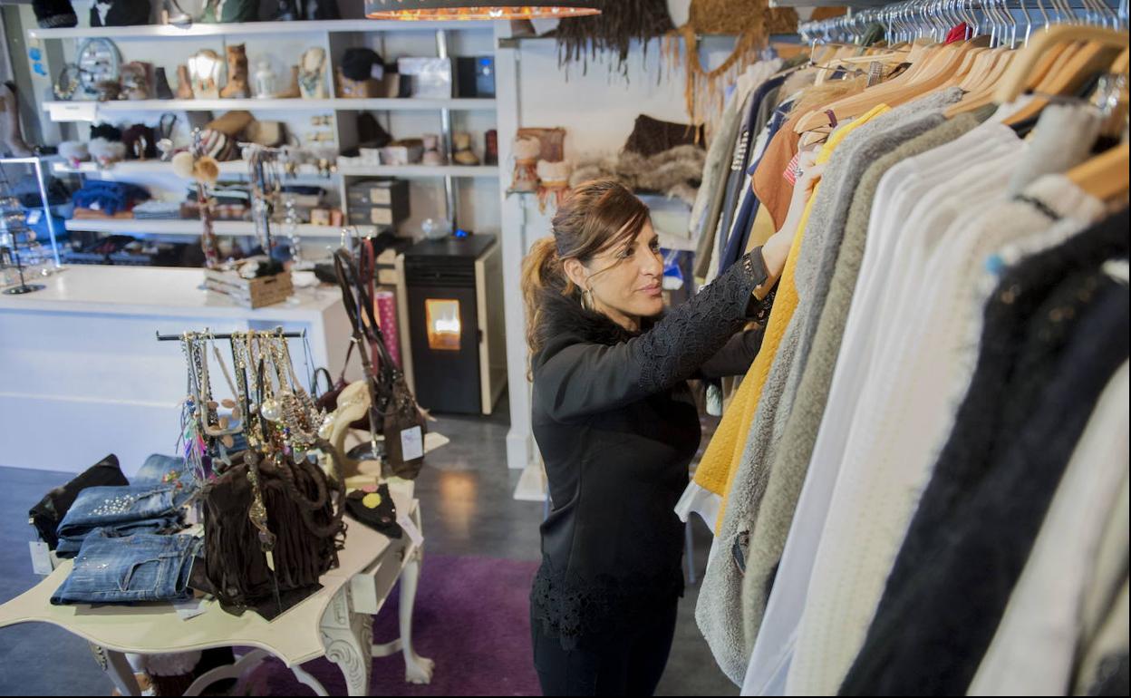 Una comerciante organiza el género de su tienda de ropa en la capital campurriana.