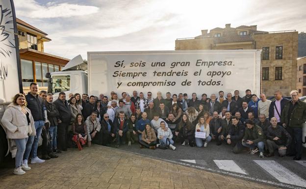 Foto de familia de los cuatro propietarios de la empresa Transportes Victoriano Saiz Echevarría e Hijos junto a sus trabajadores . 