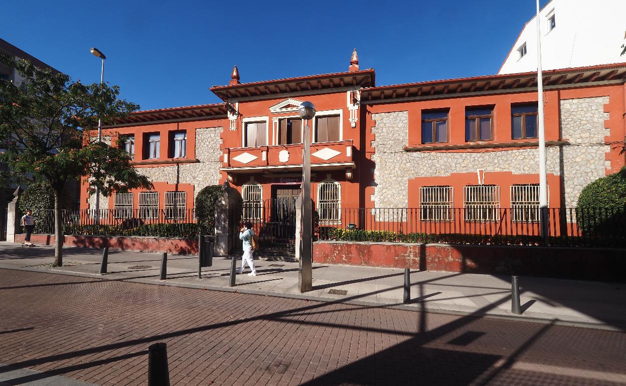 Una vecina pasa frente a la antigua sede de la Cámara de Comercio, en Torrelavega.