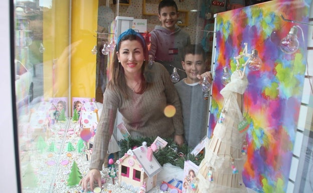 Almudena Vega junto a sus hijos Lucas y Nicolás durante el montaje del escaparate de Barve que han hecho juntos 