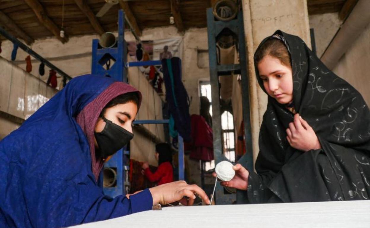 Mujeres afganas tejen alfombras en un taller de la provincia de Herat. 