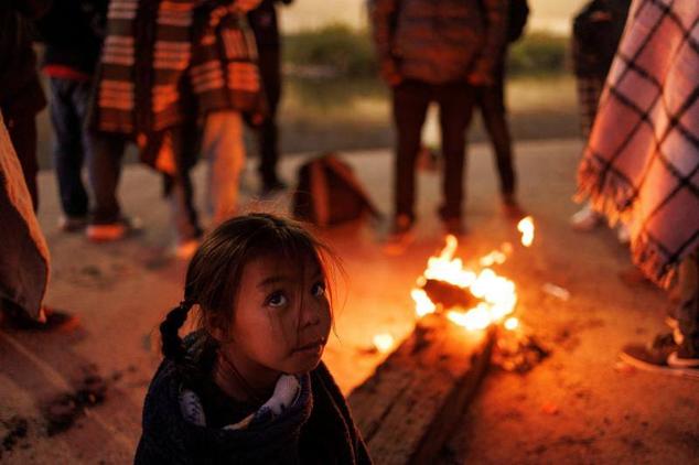 Blaidimar, venezolana de ocho años, se sienta junto a una hoguera para calentarse mientras espera con su familia asilo en EE UU, en el río Bravo, frontera entre México y EE UU, en Ciudad Juárez, México.