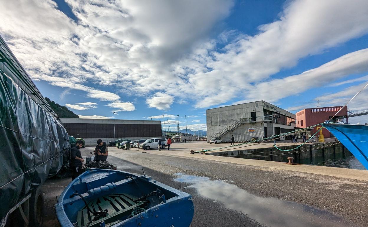 Dos pescadores trabajan en su embarcación en las proximidades de la lonja del puerto pejino. 