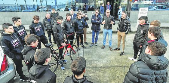 Igor González de Galdeano, con Samuel Sánchez a su izquierda y Rafael Gómez a su derecha, explica a los jóvenes ciclistas el proyecto en la entrada de la planta de Gomur. javier cotera