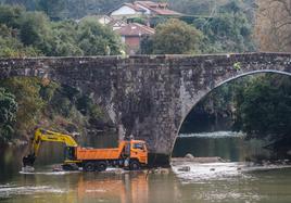 La compleja obra para reformzar los pilares del puente dejó llamativas escenas, como la de este camión metido en pleno lecho del río