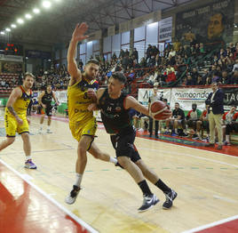 Sanz, del Alega, avanza hacia la canasta mientras Czerapowicz, del Andorra, trata de impedírselo.