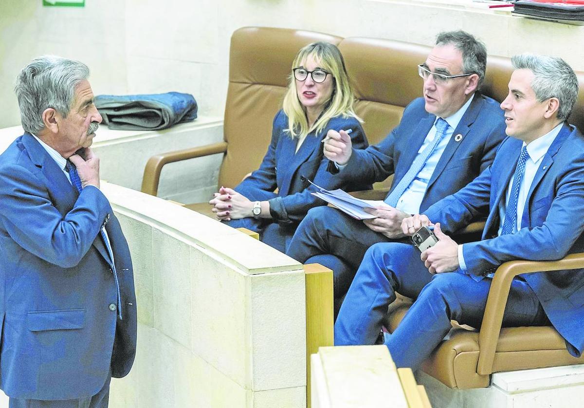 Revilla habla con la bancada socialista durante el pleno del Parlamento