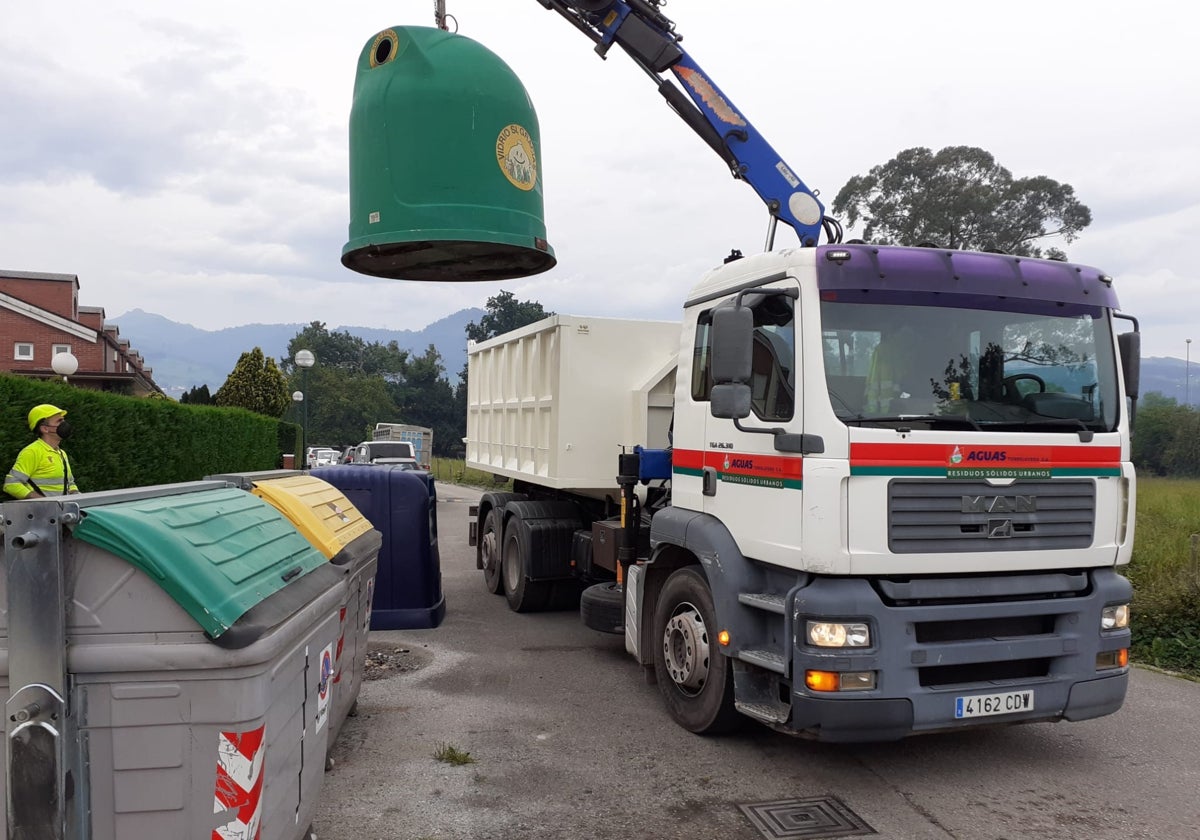 Un camión eleva un contenedor de vidrio, en Torrelavega