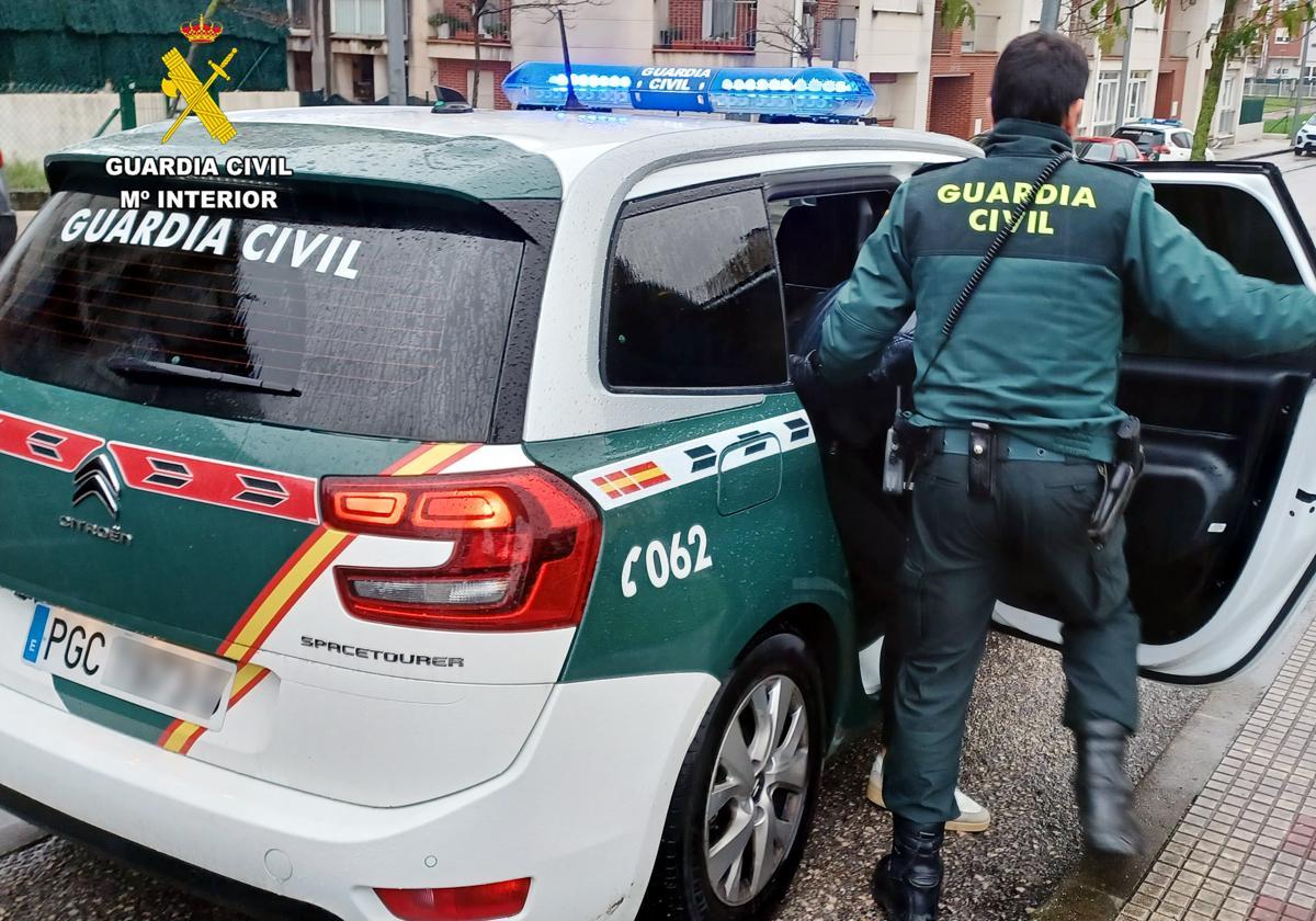 Momento en que un agente introduce al detenido en un vehículo de la Guardia Civil