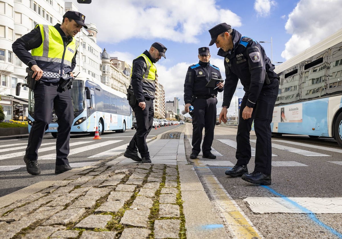 Cuatro agentes de la Policía Local de Santander realizando mediciones en el lugar del accidente.