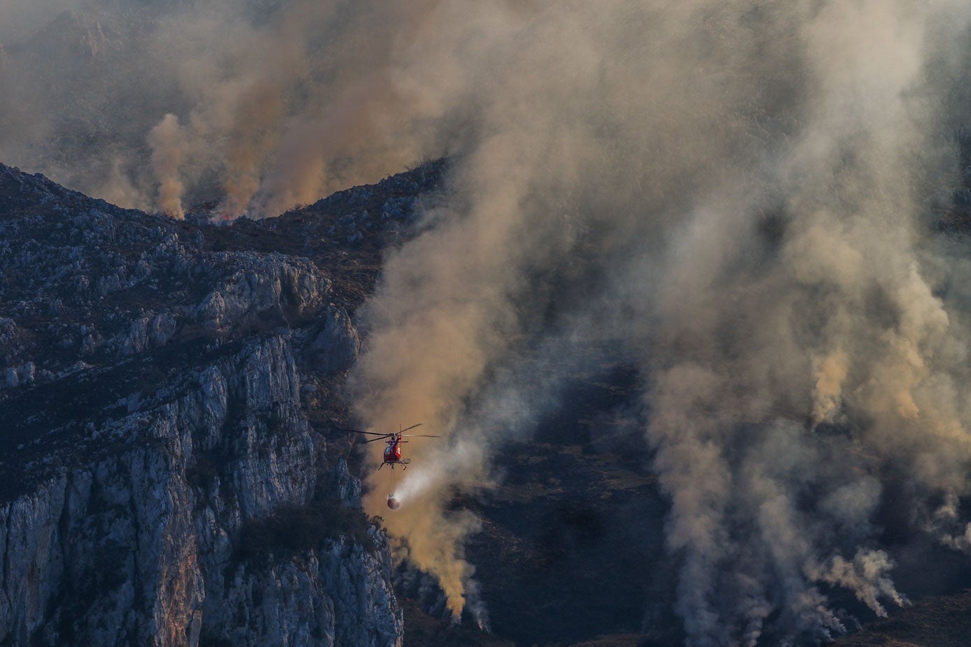 El helicóptero del 112 se adentra entre los montes en Linto (Miera) para extinguir los dos incendios activos durante esta mañana.