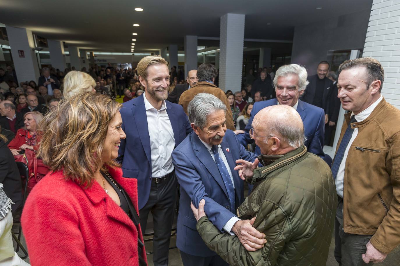 Paula Fernández, Felipe Piña, José María Fuentes Pila y Guillermo Blanco observan a Miguel Ángel Revilla saludando a un militante regionalista en el acto de presentación del candidato del PRC a la Alcaldía de Santander. 