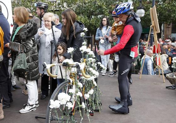 Uno de los participantes en la marcha ciclista rinde homenaje con un clavel.