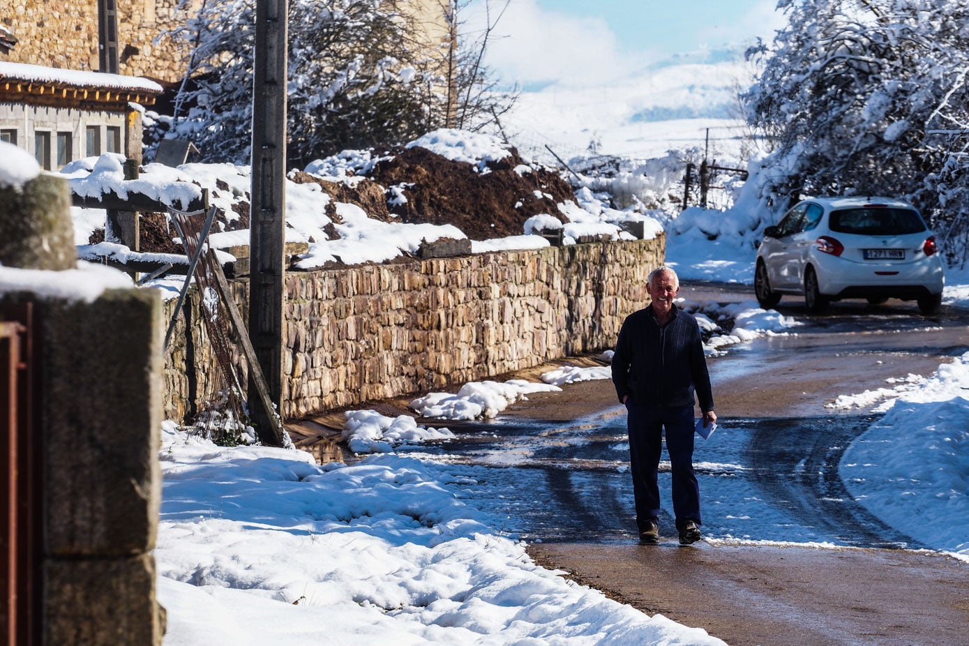 Un paisano de La Costana pasea entre la nieve disfrutando del soleado día.