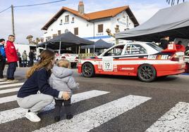 Un joven aficionado contempla el coche de los ganadores, Ricardo y Moisés Gómez.