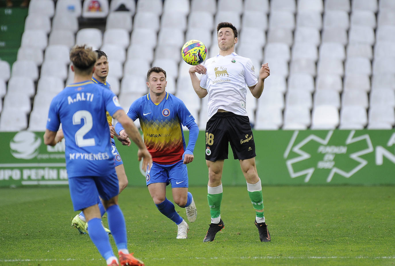 Saúl García controla el balón entre tres jugadores del Andorra.