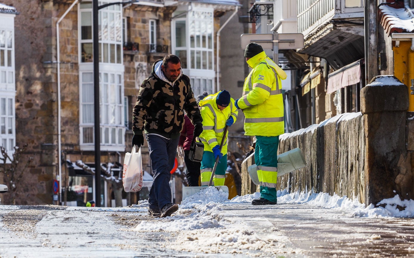 Pala en mano y mucha paciencia para quitar la nieve de las aceras en Reinosa: el trabajo de los operarios municipales es constante. 