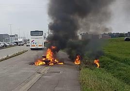 La moto ardiendo en la carretera frente al polígono de Pontejos.